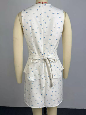 Floral peplum set in white with blue flowers, featuring a tie waist and ruffled hem.