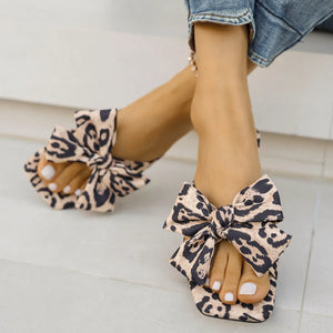 Leopard print bow flat sandals with a square toe.