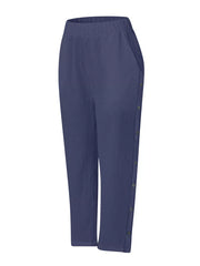 Navy blue relaxed fit pants with decorative side buttons and pockets.