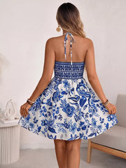Floral halter neck mini dress with smocked bodice and cutout back detail.