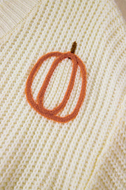 Beige knit sweater with embroidered pumpkin detail.