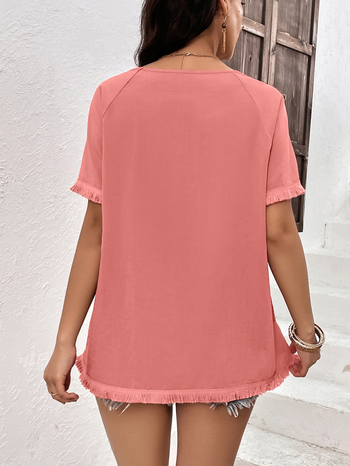 Coral raglan sleeve tee with fringed hem and sleeves.