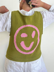 Olive knit tank top with a large pink smiley face graphic on the back.