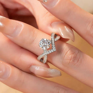 Sterling silver crossover ring with moissanite stones and a central 1ct round cut stone.