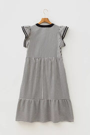 Black and white striped tiered midi dress with ruffle sleeves and pockets.