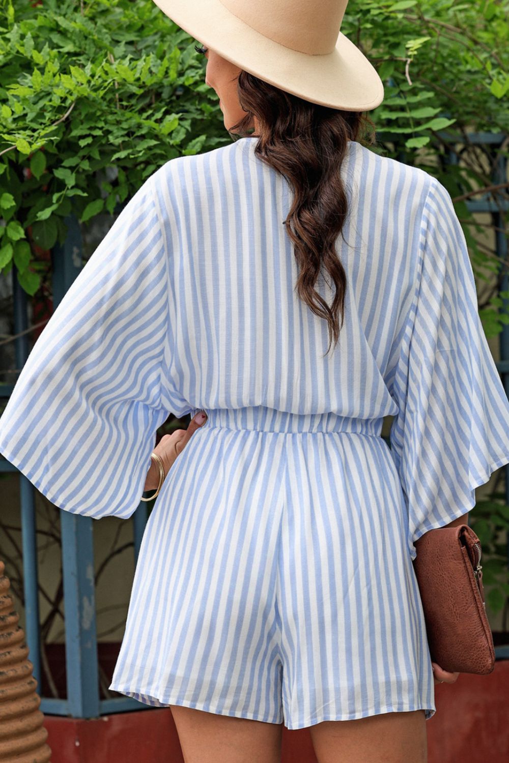 Light blue and white striped tie-front kimono jumpsuit with wide sleeves and elastic waist.