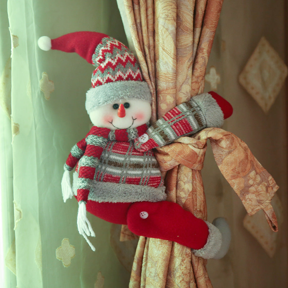 Snowman curtain tieback with red hat, scarf, and plaid sweater, holding back gold curtains.