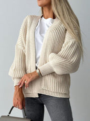 Beige textured puff sleeve cardigan with ribbed knit and open front.