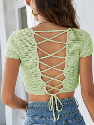 Light green crochet crop top with short sleeves and a lace-up back detail.
