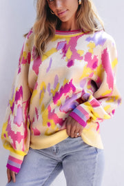 Abstract brushstroke knit sweater with puff sleeves and striped cuffs in floral colors.
