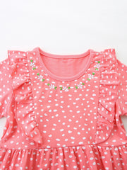 Coral polka dot cotton dress with ruffled sleeves and floral embroidery detail.