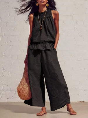 Black smocked peplum top and flowing pants set with ruffled neckline and wide legs.