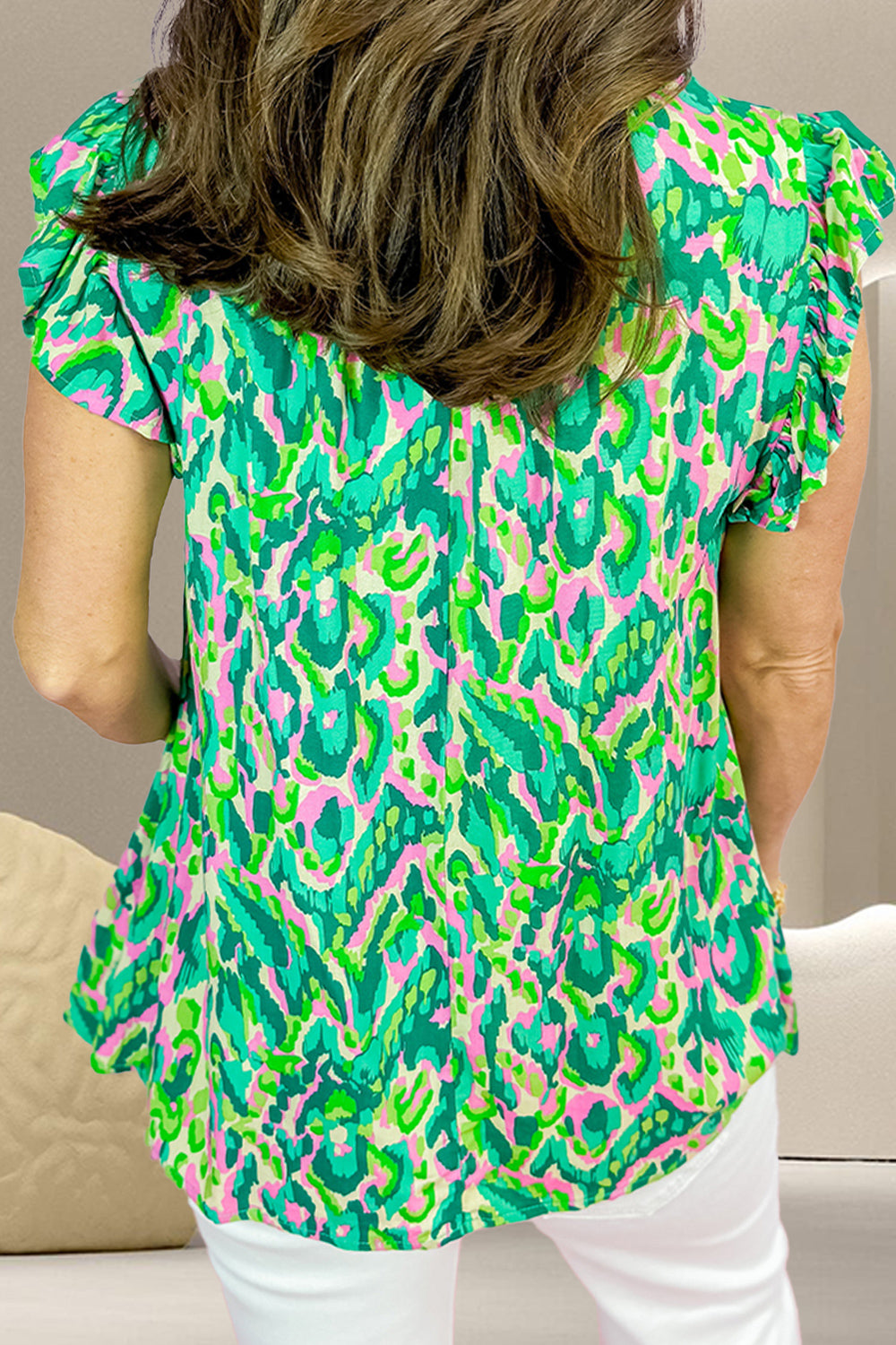 Green abstract print cap-sleeve blouse with ruffle details.