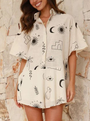 Beige linen romper with celestial print, short sleeves, collared neckline, and button front.