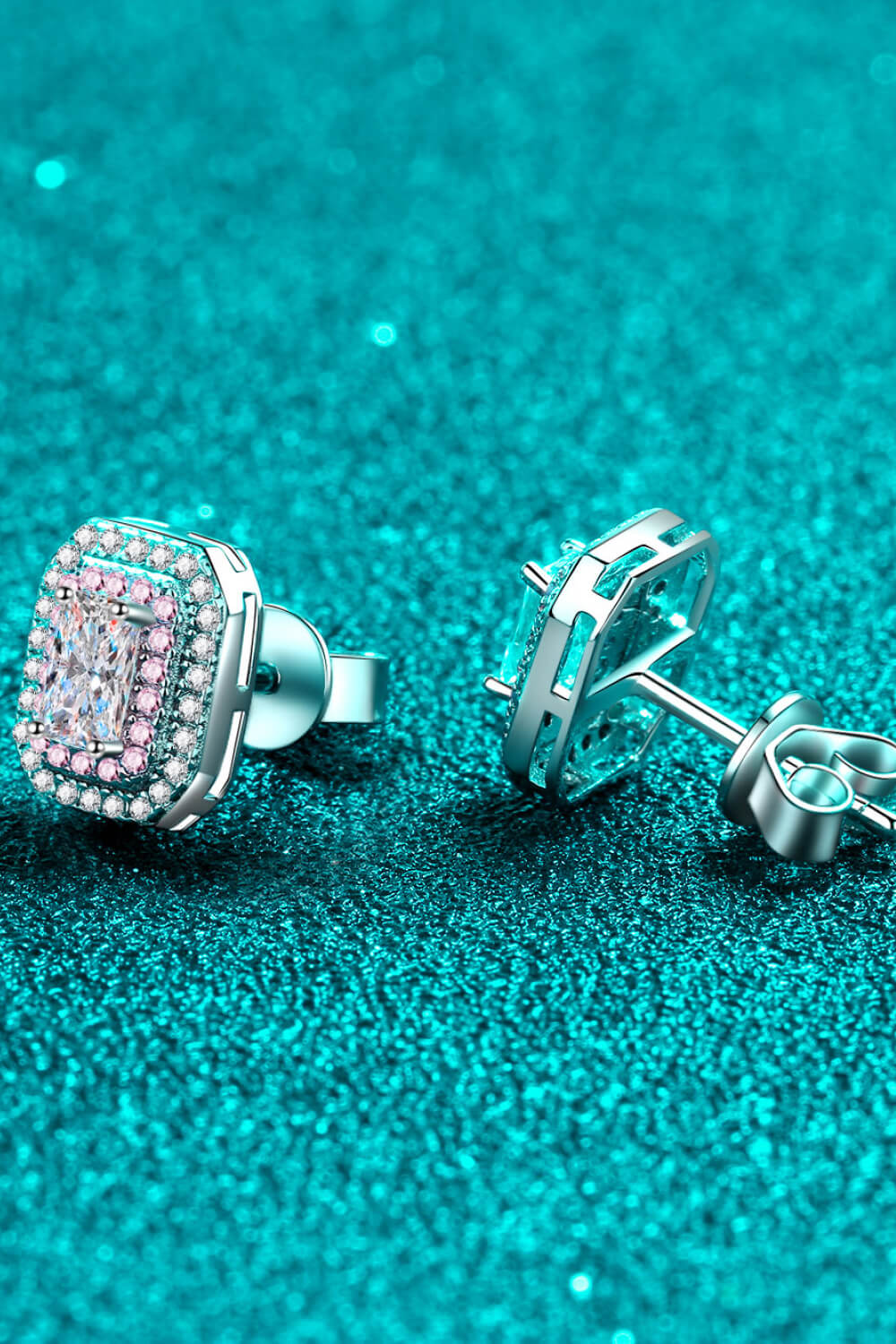 Radiant Emerald-Cut Halo Studs in silver with a central diamond and pink accent stones.