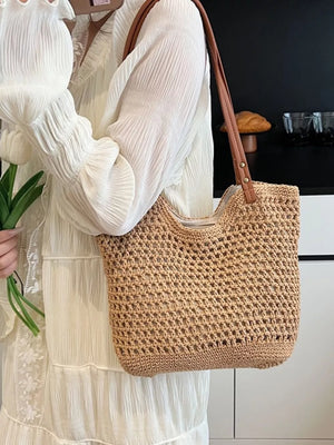 Artisan woven straw shoulder bag in beige with leather straps.