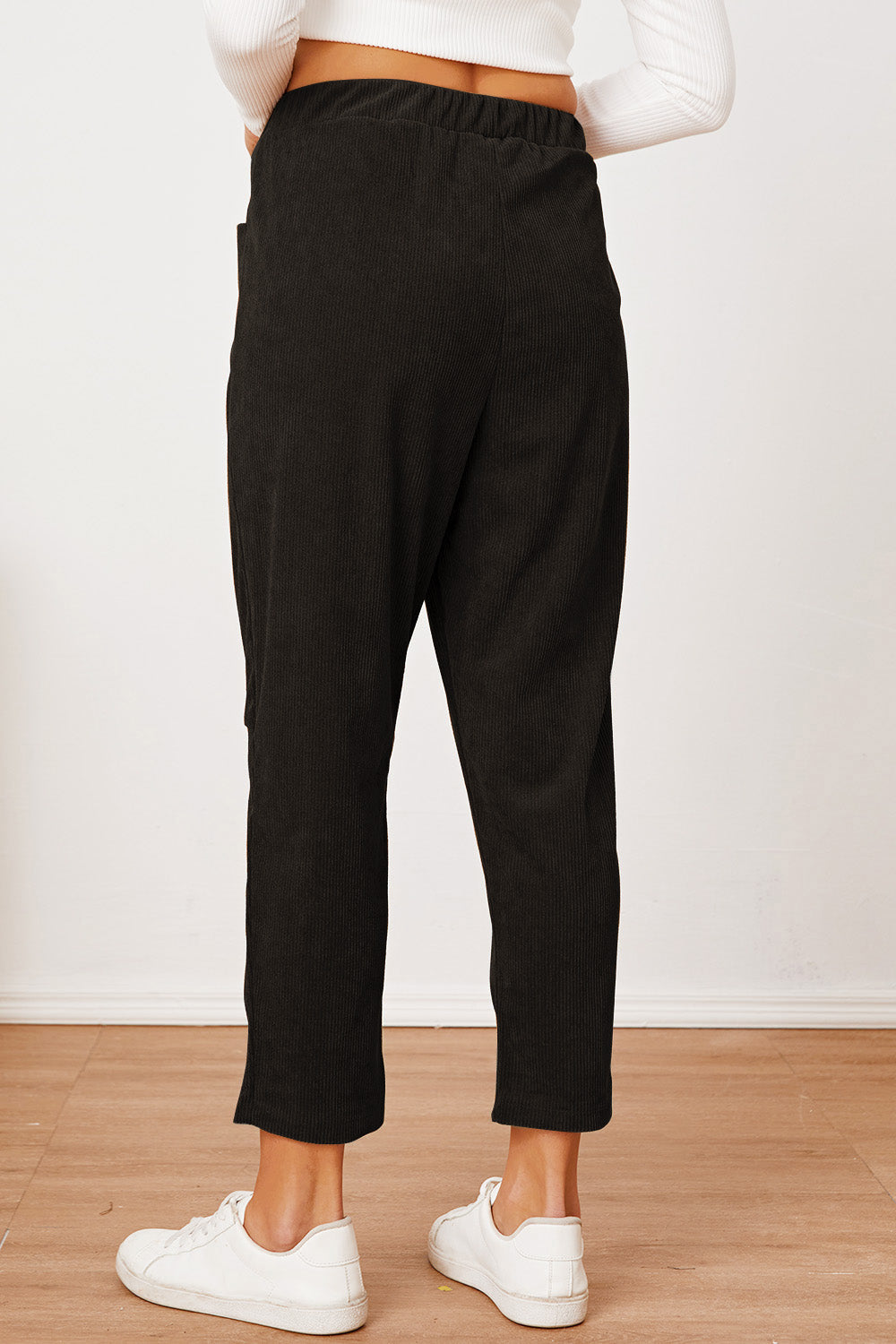 Black corduroy barrel-leg utility pants with elastic waistband and cropped length.