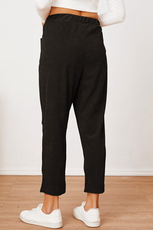 Black corduroy barrel-leg utility pants with elastic waistband and cropped length.
