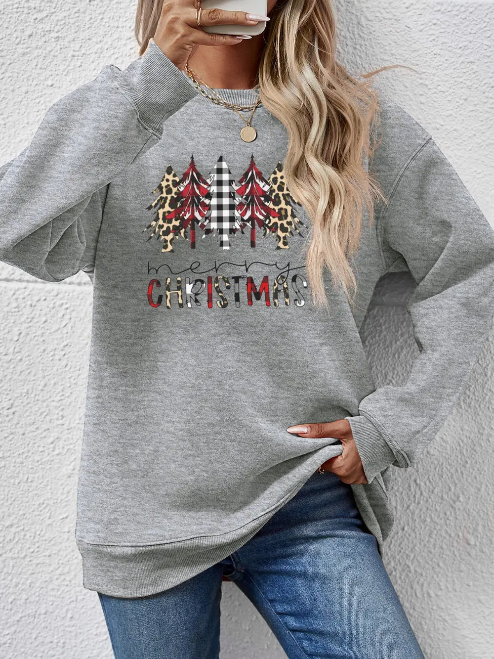 Gray crewneck sweatshirt with Christmas trees and Merry Christmas graphic.