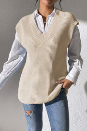 Beige textured knit V-neck sleeveless top with ribbed detail, styled over a white shirt.
