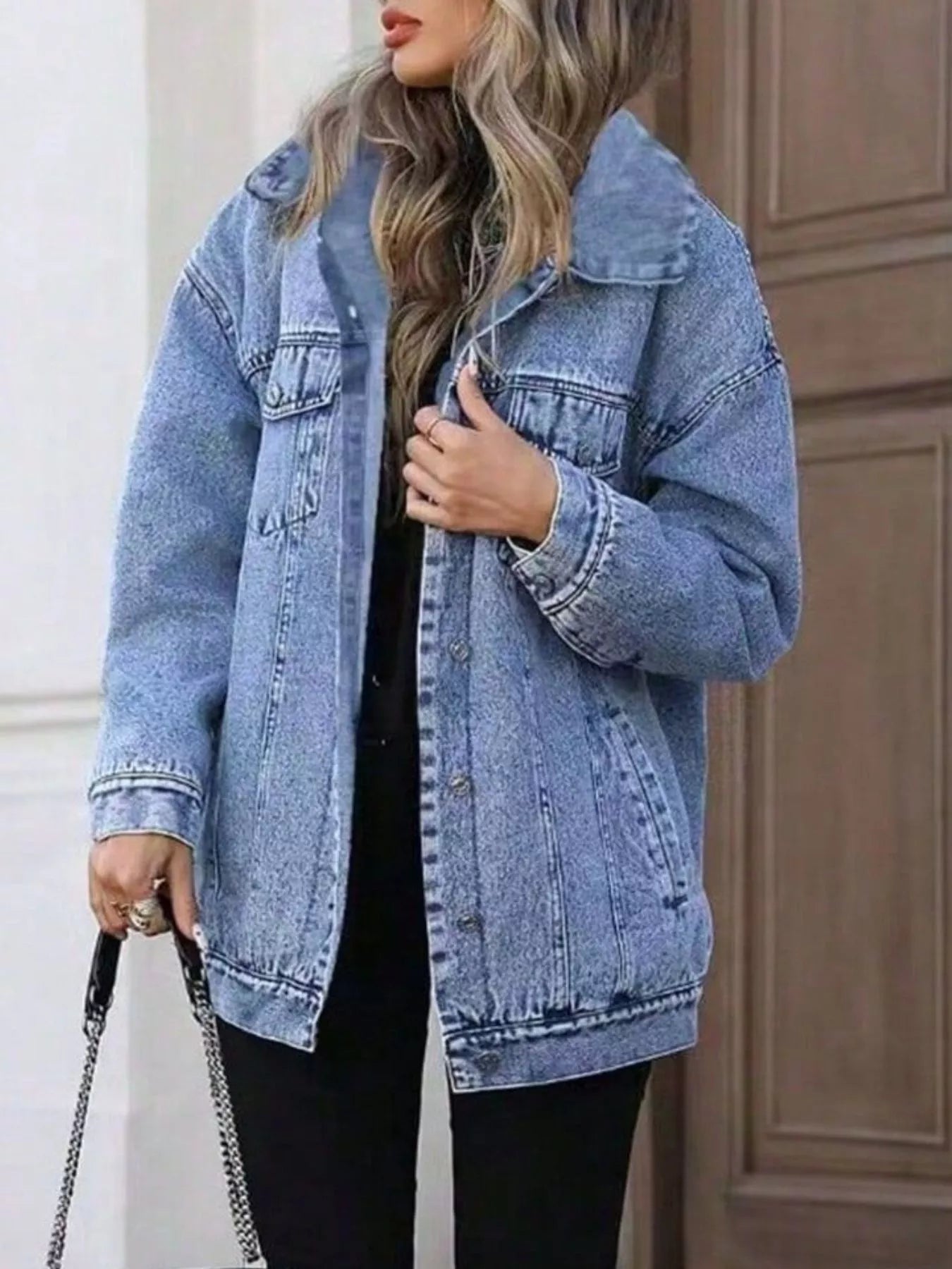 Oversized washed blue denim jacket with button front and chest pockets.