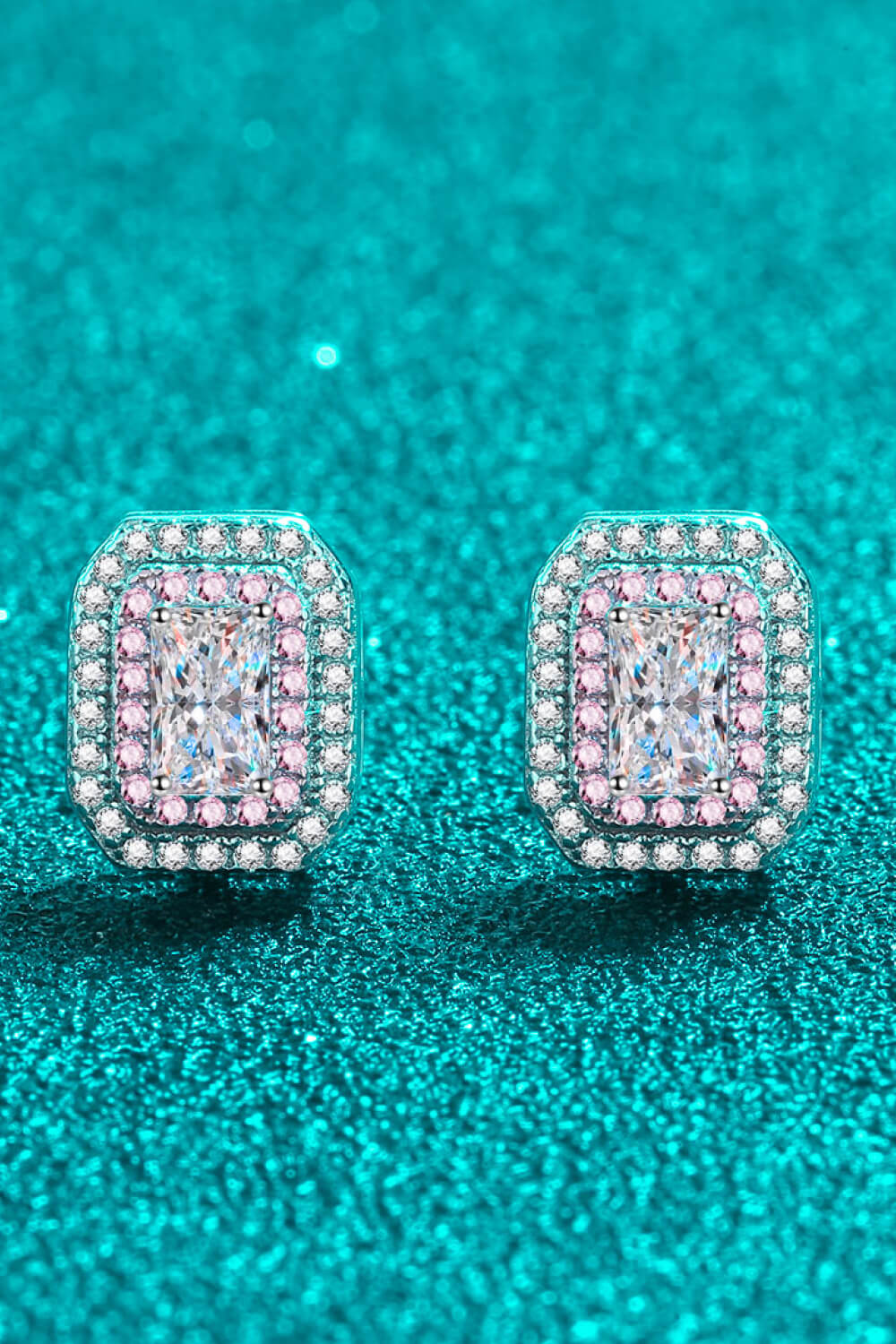 Silver halo stud earrings with emerald-cut center stone and pink accent stones.