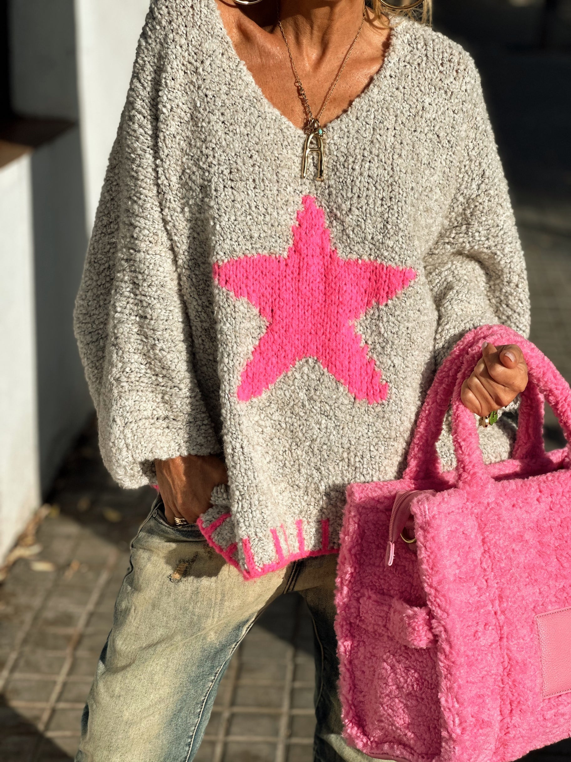 Acrylic knit v-neck pullover sweater with a large hot pink star detail and ribbed trim.