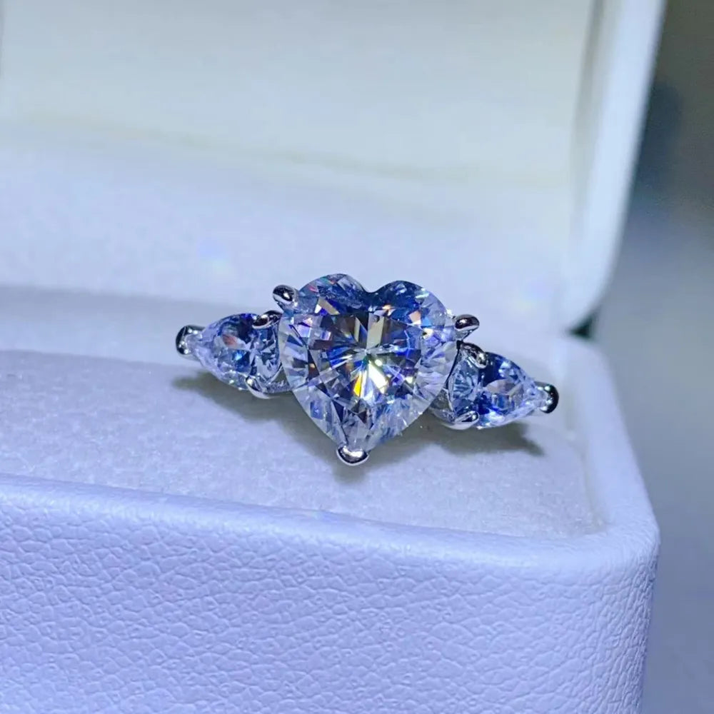 Silver heart-cut diamond trilogy ring with pear-shaped side stones.