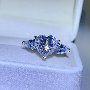 Silver heart-cut diamond trilogy ring with pear-shaped side stones.