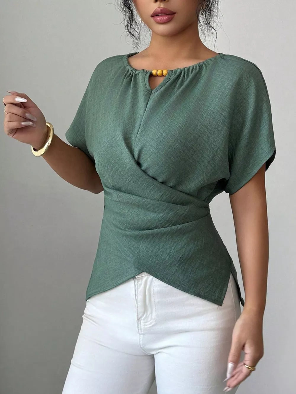 Green short sleeve maternity blouse with beaded keyhole neckline and wrap detail