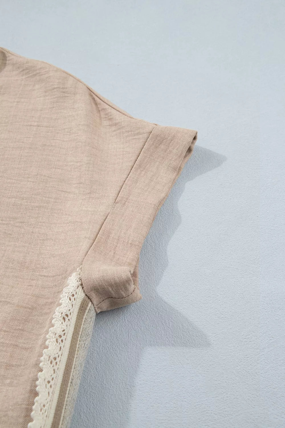 Beige crochet lace pullover with rolled sleeves and textured fabric.