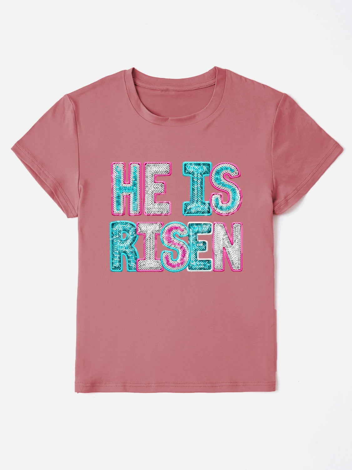 Dusty pink crewneck t-shirt with sequin-textured "He Is Risen" graphic.