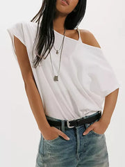 White asymmetrical t-shirt with relaxed fit and one shoulder detail, styled with jeans.