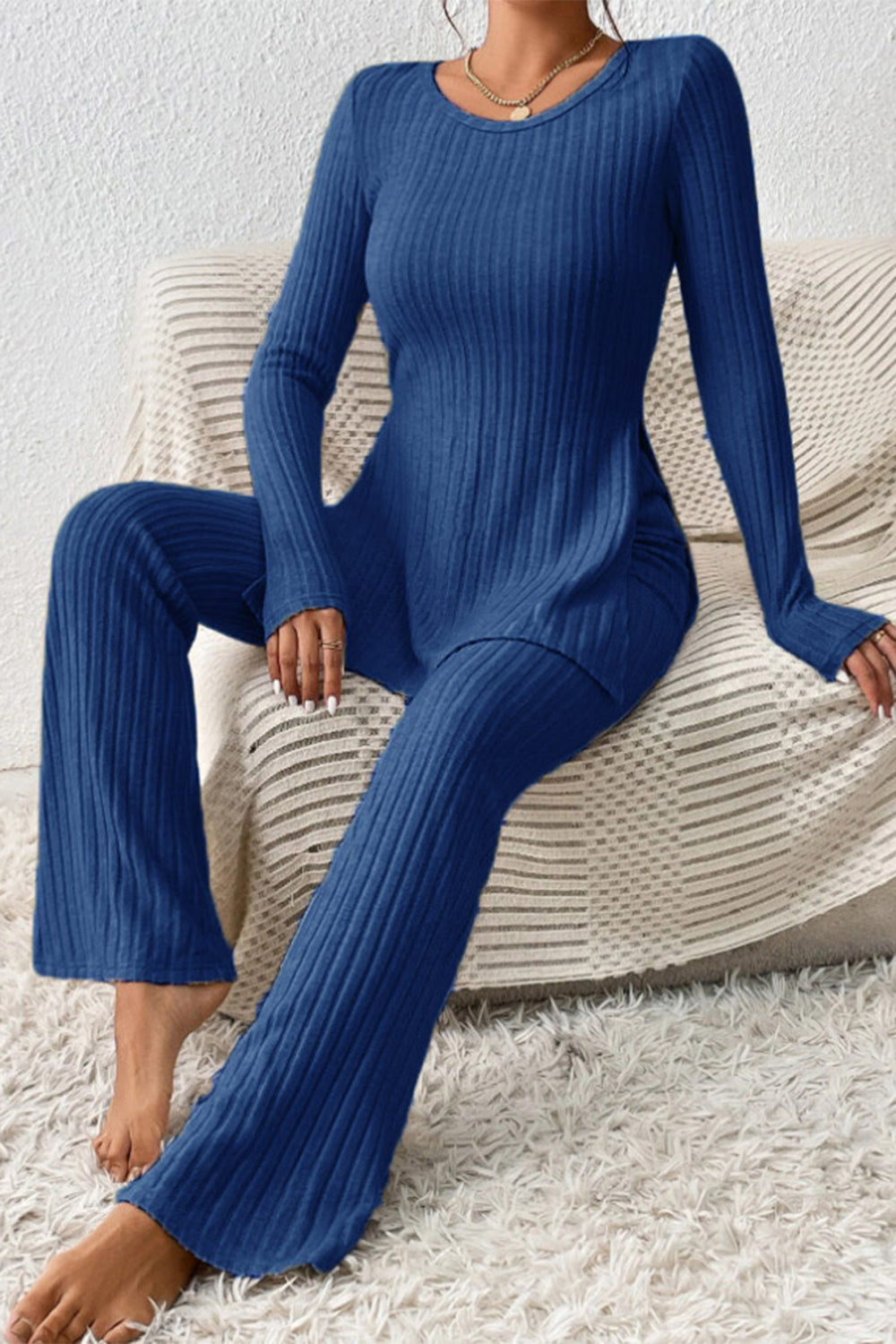 Royal blue ribbed knit co-ord set with long sleeves and flared pants with side slits.