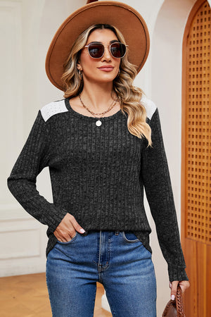 Black ribbed knit top with eyelet shoulder detail and crew neck.