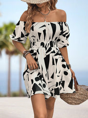 Off-shoulder mini dress with geometric print, shirred waist, and balloon sleeves.
