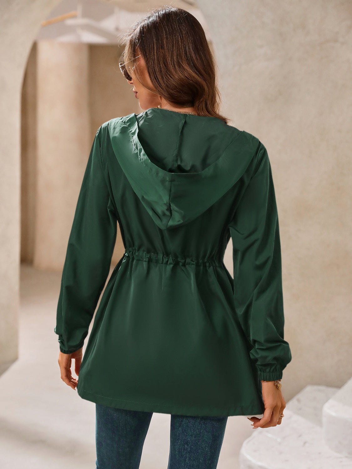 Dark green hooded jacket with cinched waistline and adjustable drawstring.