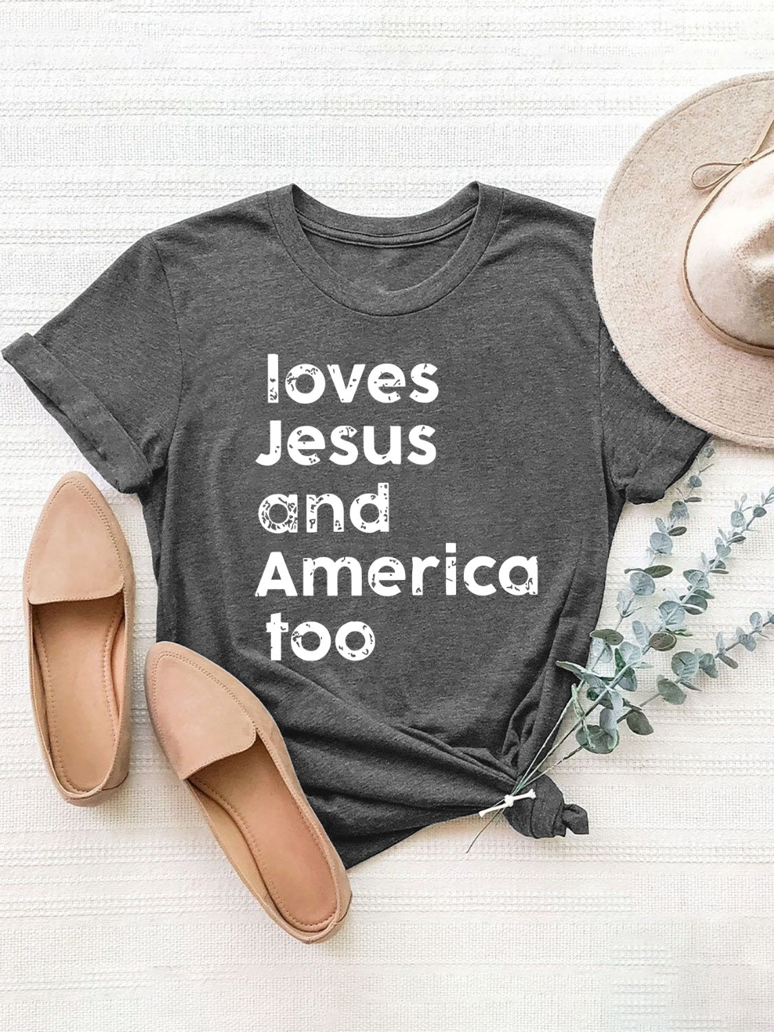 Dark gray crew neck tee with white "loves Jesus and America too" graphic.
