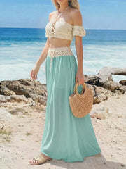 Crochet bandeau top with lace-up detail and off-the-shoulder sleeves paired with a pastel blue maxi skirt.