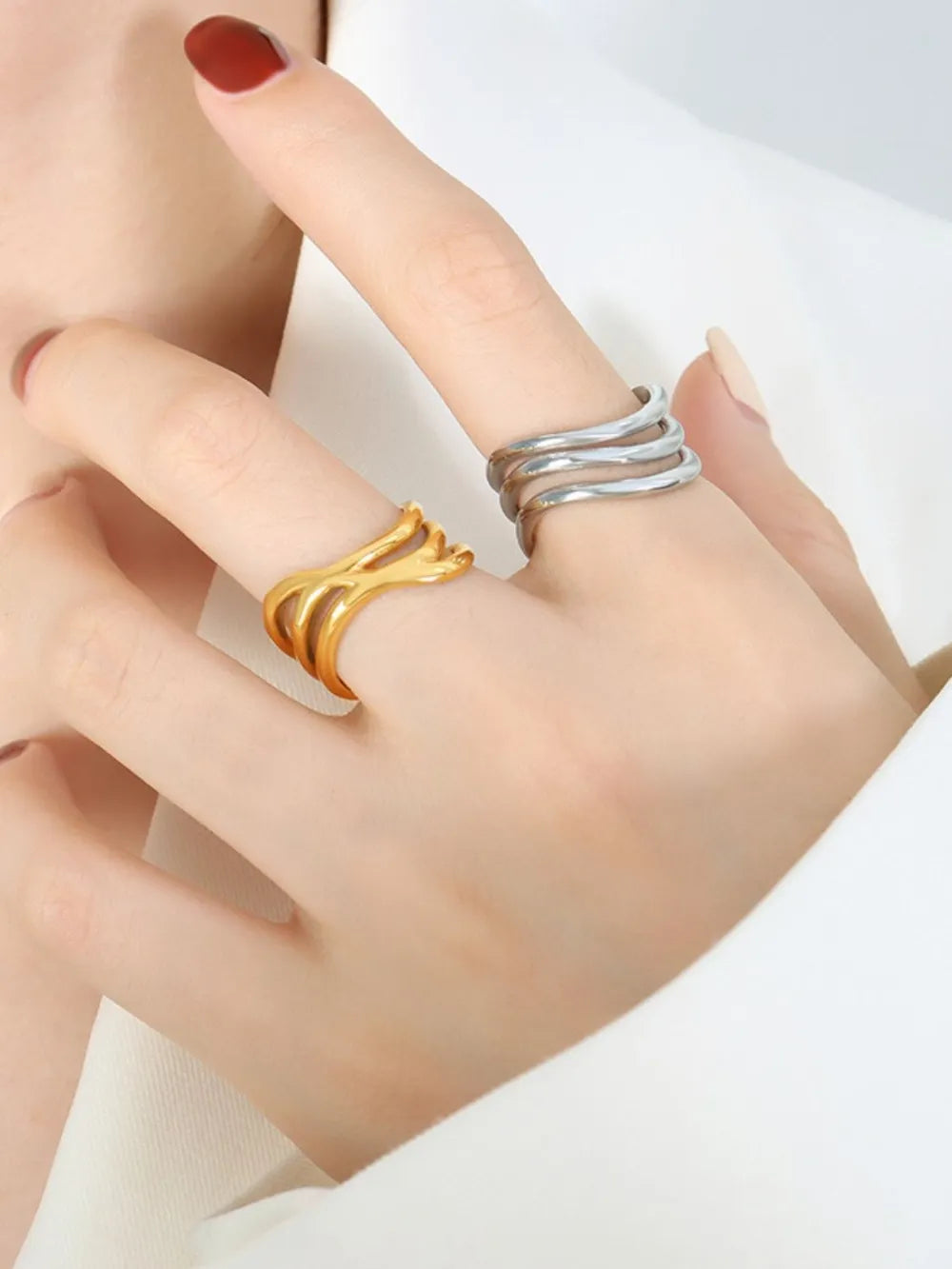 Gold and silver triple-band sculptural rings shown on fingers