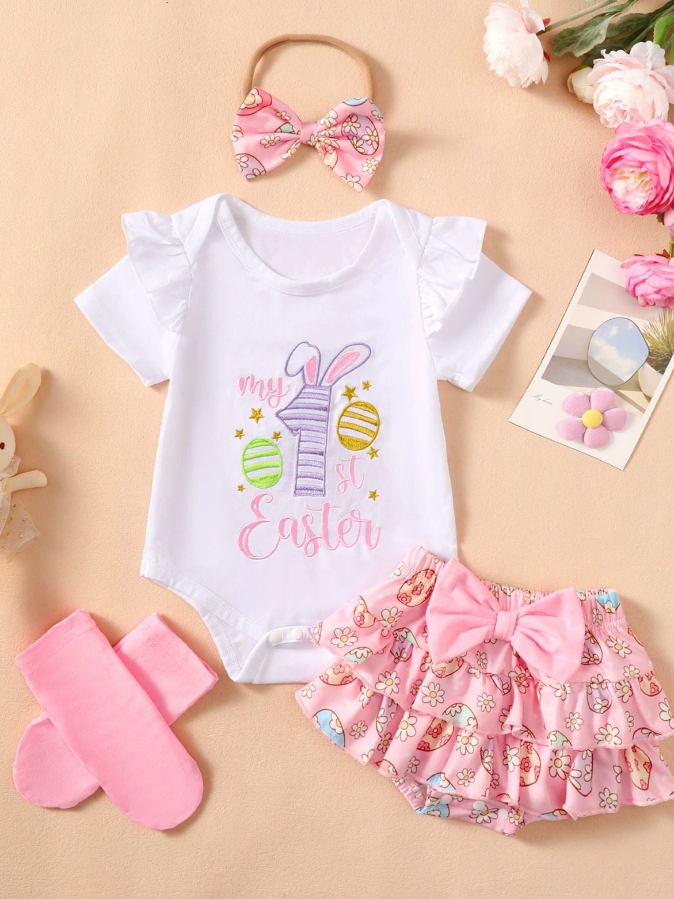 White ruffled bodysuit with "my 1st Easter" embroidery and pink ruffled skirt with egg print.