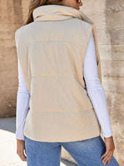 Ribbed corduroy zip-up vest coat in off-white with a high collar, worn over a white long-sleeve shirt.