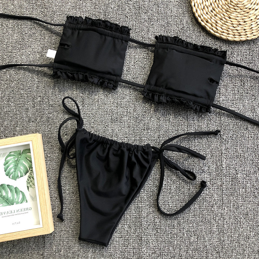 Black bandeau bikini set with ruffled trim and tie-side bottoms.