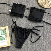 Black bandeau bikini set with ruffled trim and tie-side bottoms.
