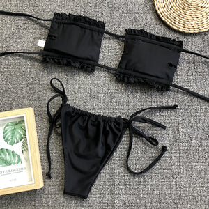 Black bandeau bikini set with ruffled trim and tie-side bottoms.