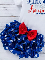 Baby outfit set with white top and ruffled bloomer shorts in blue with white stars and a red bow.