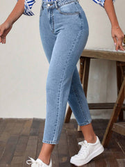 Light wash denim jeans with a slim-fit ankle cut, styled casually with white sneakers.