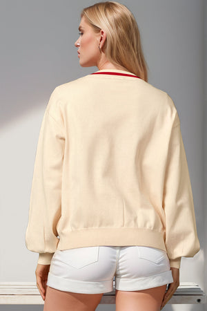 Cream acrylic cardigan with red trim and balloon sleeves
