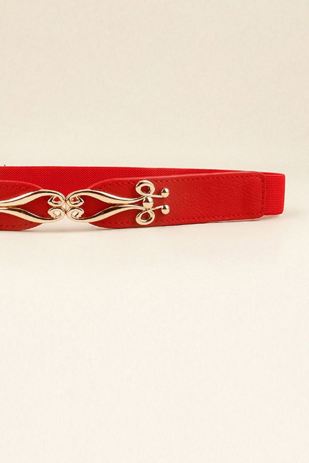Red elastic waist belt with sculpted alloy clasp and faux leather front panel