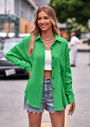 Green textured gauze overshirt with relaxed silhouette and button front, styled with denim shorts.
